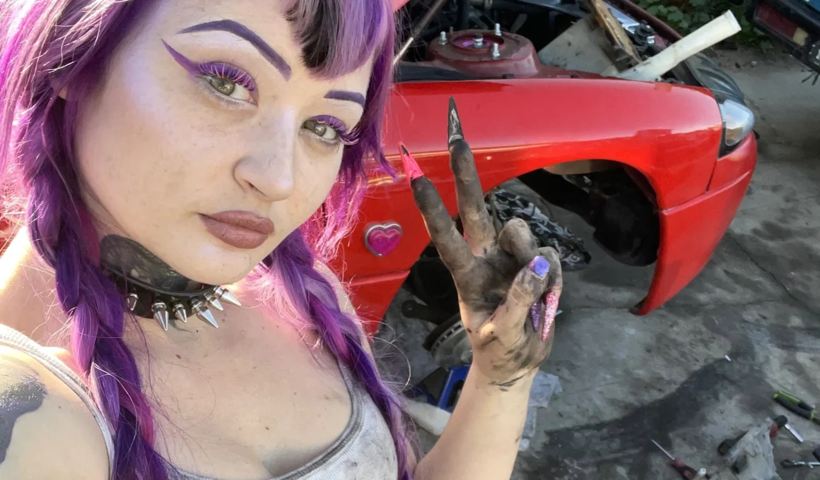 Peyton working as a mechanic posing for a photo