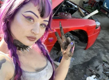 Peyton working as a mechanic posing for a photo