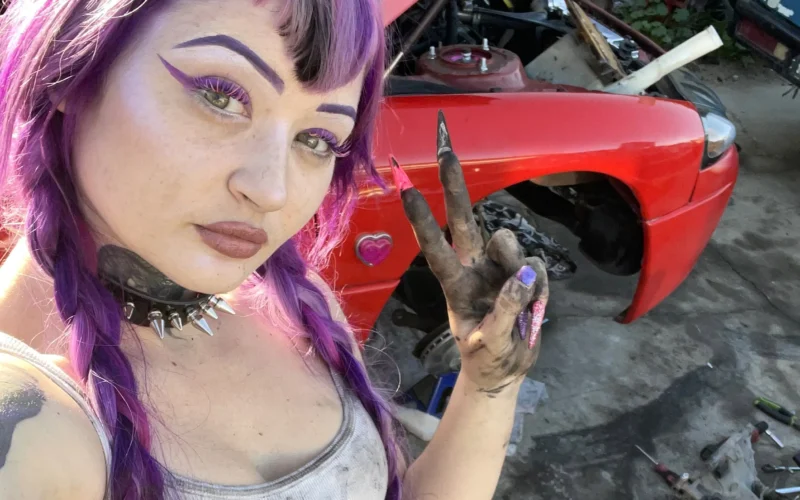 Peyton working as a mechanic posing for a photo