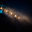 Row of stage spotlights hanging from a ceiling, representing mainstream celebrities crossing into the creator economy