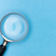 Magnifying glass on a plain background, representing the search for discoverability on creator platforms