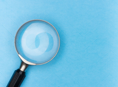 Magnifying glass on a plain background, representing the search for discoverability on creator platforms