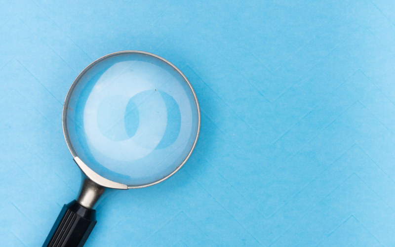 Magnifying glass on a plain background, representing the search for discoverability on creator platforms
