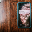 Smartphone on a wooden surface showing a message notification, representing fan engagement and retention for creators