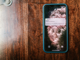 Smartphone on a wooden surface showing a message notification, representing fan engagement and retention for creators