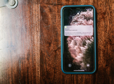 Smartphone on a wooden surface showing a message notification, representing fan engagement and retention for creators