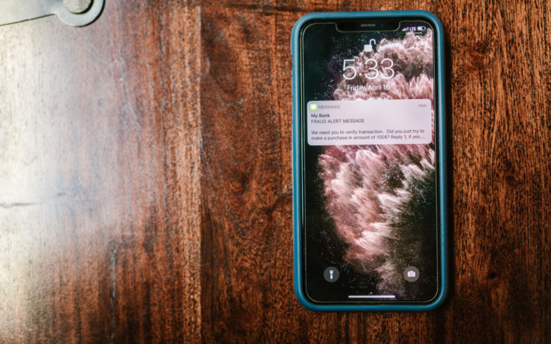 Smartphone on a wooden surface showing a message notification, representing fan engagement and retention for creators