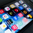 Smartphone screen full of app icons, representing a comparison between creator subscription platforms